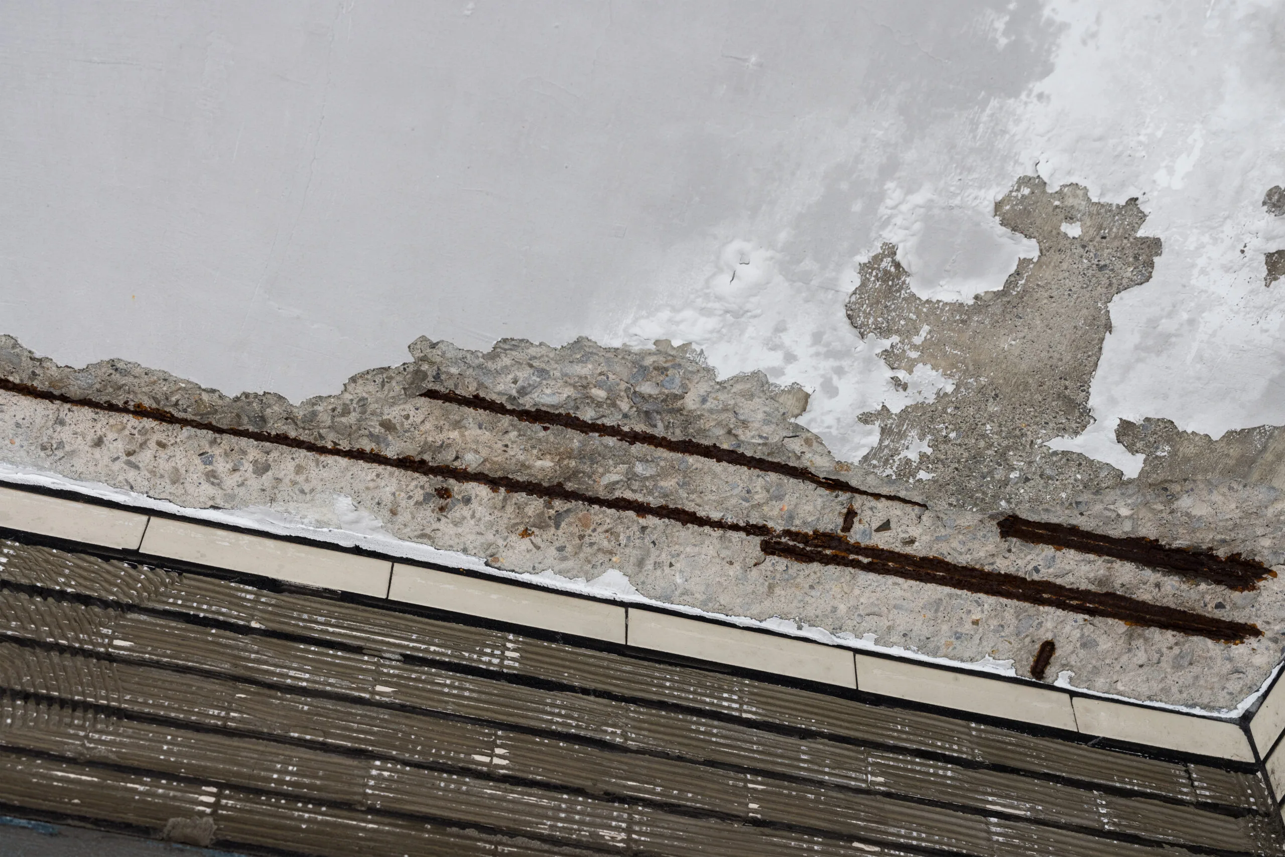 Structural damage from a roof leak showing cracked concrete and rusted steel in Brooksville, FL.